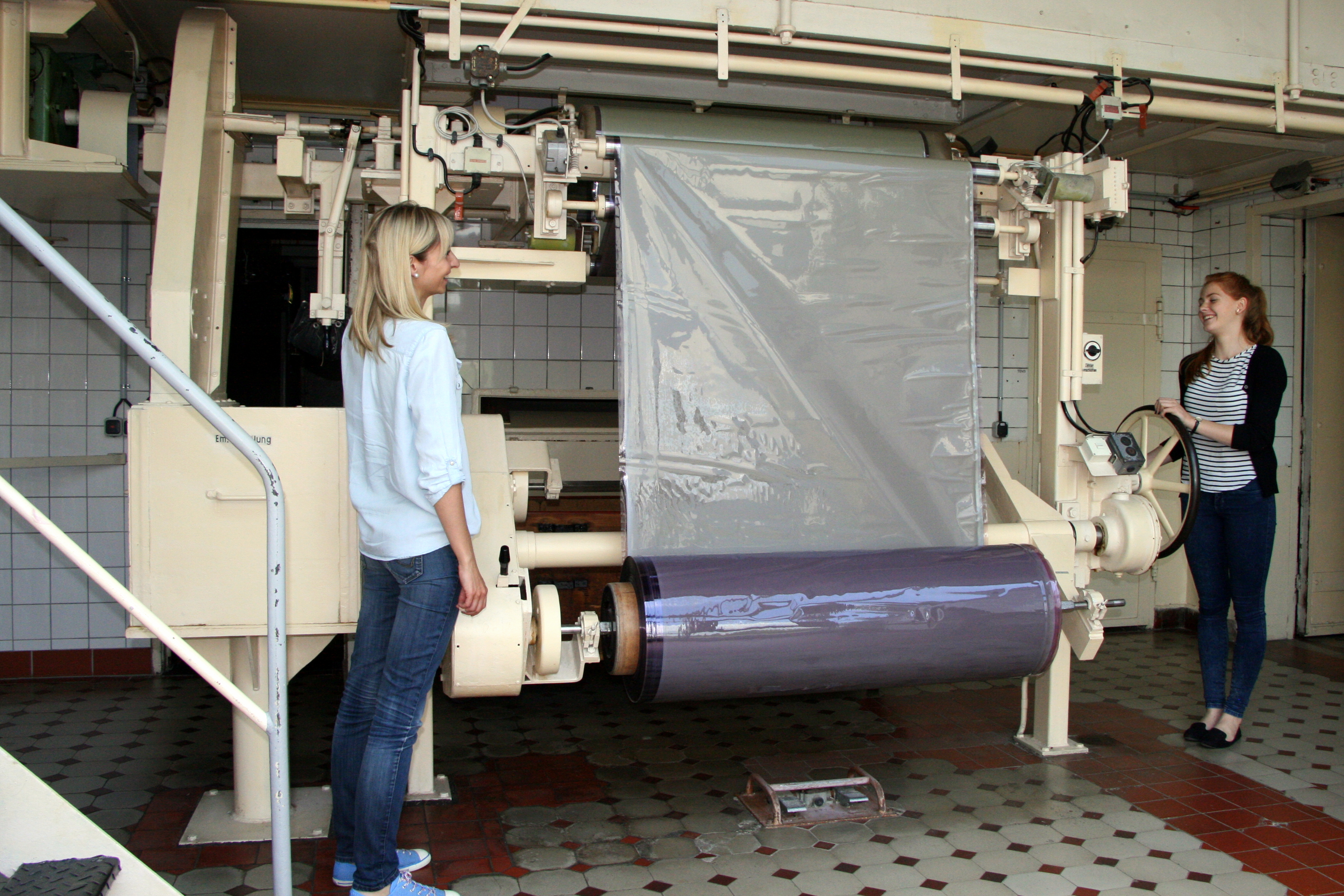 zwei Frauen vor einer Maschine zur Filmherstellung im Industrie- und Filmmuseum Wolfen