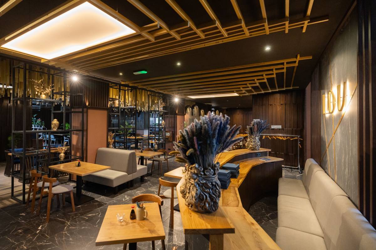 Gemütlich eingerichteter Sitz- und Essbereich mit dekorativen Pflanzen und Tischgedeck im Lou Restaurant Dessau.