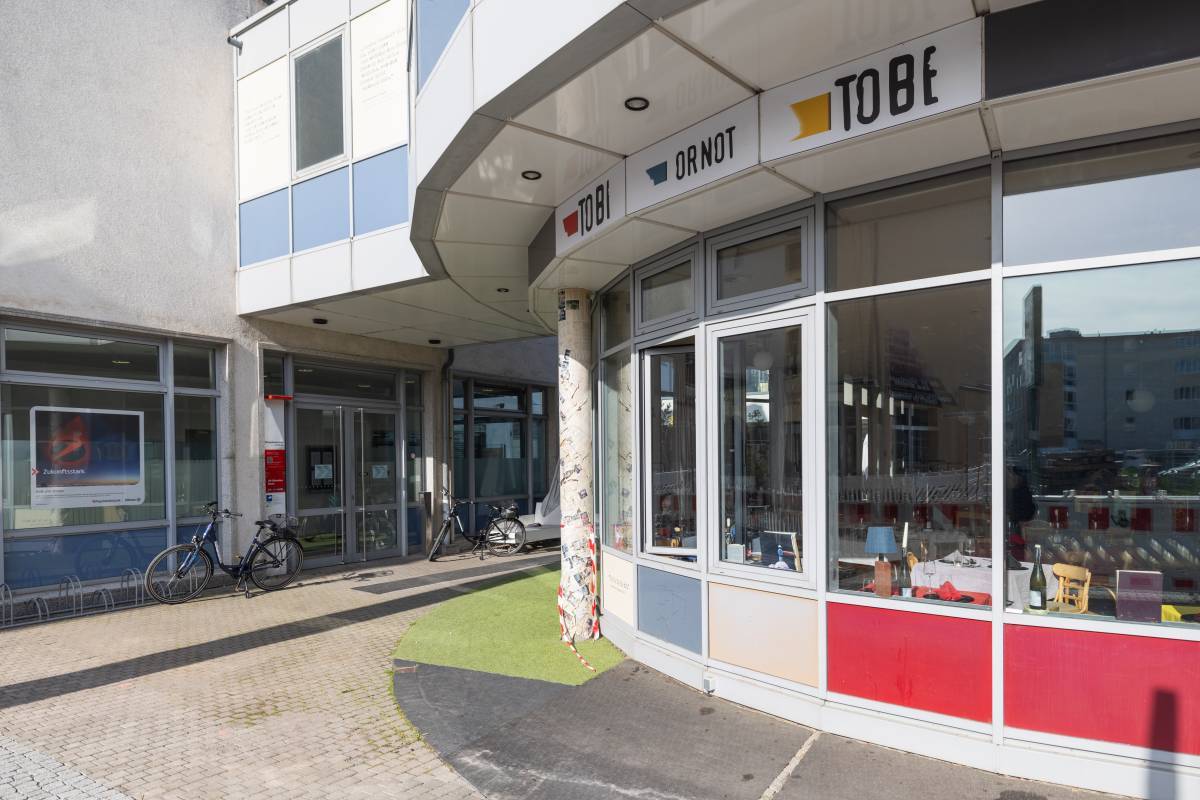 Außenansicht des abgerundeten Eingangsbereich des Restaurant Tobi ORNOT ToBe Dessau mit bunten Akzenten und auffälligem Design.