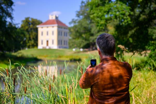 Mann macht ein Foto mit dem Smartphone vom Luisium
