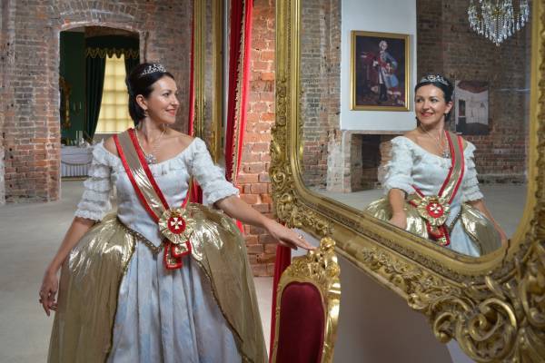 Frau im Kostüm von Katharina der Großen steht vor einem Spiegel im Schloss Zerbst