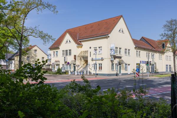 IMG Sachsen-Anhalt/shapefruit AG Begrünte Sicht auf das Gebäude des Athos Restaurant Dessau mit Treppenaufstieg zum Eingang direkt an der Straße.