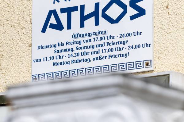 IMG Sachsen-Anhalt/shapefruit AG Detailaufnahme des Restaurantschild vom Athos Restaurant Dessau mit blauer Schrift.